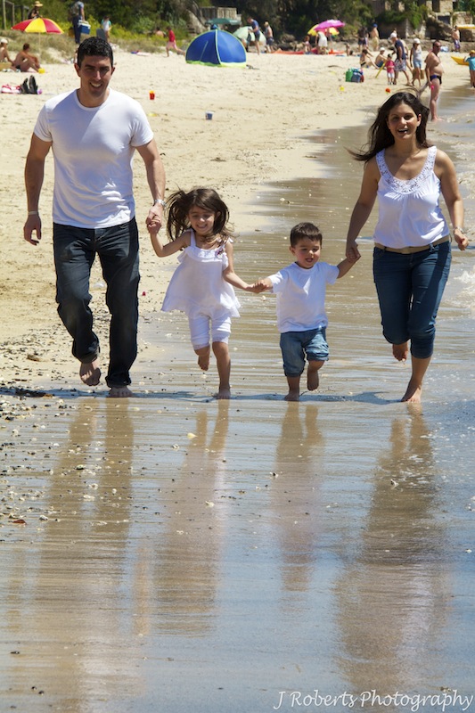Family running along the beach - family portrait photography